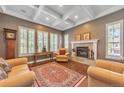 Cozy living room boasts coffered ceilings, a tiled fireplace, and shuttered windows providing ample natural light at 6761 Mary Ct, Castle Pines, CO 80108