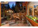 Cozy cabin exterior featuring a beautifully decorated wooden deck and vibrant flower boxes at 30264 Upper Bear Creek Rd, Evergreen, CO 80439
