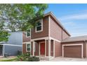 Attractive two-story home with brown siding, front garden and attached garage at 5168 Goshawk St, Brighton, CO 80601