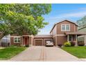 Suburban home showcasing inviting curb appeal with a long driveway and green lawns at 5168 Goshawk St, Brighton, CO 80601