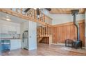 Open-concept living area with wood-burning stove, exposed beams, and staircase at 166 S Fuller Placer Rd # 5, Breckenridge, CO 80424