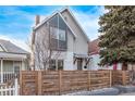 Two-story home with unique architectural details, including a modern window design and wood fence at 3339 Tejon St, Denver, CO 80211