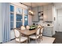 Comfortable dining area with a wooden table, upholstered chairs, and natural light from large windows at 2572 Iola St, Aurora, CO 80010