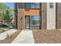 Modern home featuring a stylish front door, brick and wood accents, and a well-maintained walkway at 701 E 24Th Ave, Denver, CO 80205