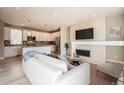 Open-concept living room features modern fireplace, comfortable seating, and a view of the gourmet kitchen at 701 E 24Th Ave, Denver, CO 80205