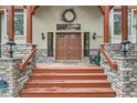 Inviting entryway with a solid wood door, stone pillars, and decorative wall lanterns creating a warm ambiance at 1662 Gore Dr, Larkspur, CO 80118