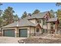 Spacious three-car garage featuring painted doors and stone accents on a well maintained home exterior at 1662 Gore Dr, Larkspur, CO 80118