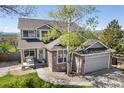 Beautiful home featuring stone accents, attached two-car garage, manicured lawn, and mature trees at 9684 W Long Dr, Littleton, CO 80123