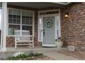 Inviting front porch featuring a cozy rocking chair, decorative wreath, and lovely landscaping at 9684 W Long Dr, Littleton, CO 80123