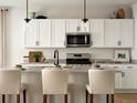 Close-up of a bright kitchen featuring white cabinets, stainless steel appliances, and light countertops at 4090 Estrella St, Brighton, CO 80601