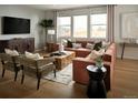 Well-lit living room featuring an L-shaped couch, a wooden coffee table, and large windows at 4090 Estrella St, Brighton, CO 80601