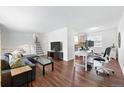 Bright living room with hardwood floors, an office area, and seamless connection to the kitchen at 11041 Newland St, Westminster, CO 80020