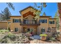 Beautiful back of house featuring a balcony, stone accents, and manicured garden at 731 Weston Rd, Larkspur, CO 80118