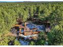 Captivating aerial perspective of a house embraced by a dense forest, highlighting its secluded and peaceful location at 18680 Arrowwood Dr, Monument, CO 80132