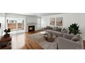 Bright living room with a fireplace, hardwood floors and sliding door access to outdoor space at 1050 S Monaco Pkwy # 125, Denver, CO 80224