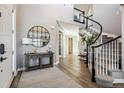 Elegant entryway featuring hardwood floors, a curved staircase, and stylish decor at 21854 Tyrolite Ave, Parker, CO 80138
