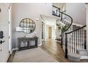 Elegant foyer with hardwood floors, a curved staircase, and stylish decor at 21854 Tyrolite Ave, Parker, CO 80138