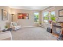 Cozy living room featuring a comfortable armchair, large windows, and neutral carpet at 2861 Eagle Cir, Erie, CO 80516