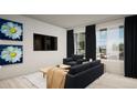 Bright living room featuring large windows, comfortable seating, and stylish decor with black-out curtains at 46545 Sunflower Ln, Bennett, CO 80102