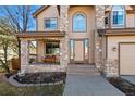 Inviting front porch with stone columns and charming bench seating at the home's entrance at 5706 S Garland Way, Littleton, CO 80123