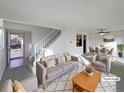 Virtually staged living room with gray sofa and dining area at 4974 E 124Th Way, Thornton, CO 80241