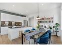 Bright dining area with modern table, comfortable seating and adjacent island with updated appliances at 1300 N Ogden St # 304, Denver, CO 80218