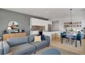 Bright living room features modern kitchen, dining area with blue velvet chairs, and hardwood floors at 1300 N Ogden St # 304, Denver, CO 80218