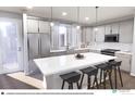 Modern kitchen with white cabinets, stainless steel appliances and a center island with stool seating at 1593 W 166Th Ave, Broomfield, CO 80023