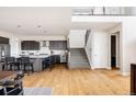 Open-concept kitchen with a large island, stainless steel appliances, and staircase to the second level at 6021 N Boston Ct, Denver, CO 80238