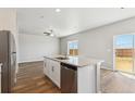 Kitchen island with stainless steel dishwasher and sink with view of the backyard at 48285 Shetland Dr, Bennett, CO 80102