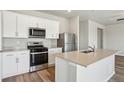 Modern kitchen with stainless steel appliances, island with sink, and ample countertop space at 48285 Shetland Dr, Bennett, CO 80102