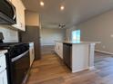 Modern kitchen with stainless steel appliances, a kitchen island, and hardwood flooring at 48285 Shetland Dr, Bennett, CO 80102