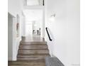 Bright entryway featuring wood floors, a staircase, and an open view of the dining area at 6103 S Millbrook Ct, Aurora, CO 80016