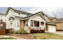 Charming two-story home with a stone facade, front porch, and landscaped front yard at 6103 S Millbrook Ct, Aurora, CO 80016
