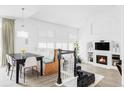 Open concept living area with a dining table, banquette seating, and a cozy fireplace at 6103 S Millbrook Ct, Aurora, CO 80016