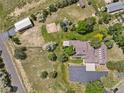 An aerial view of the entire property including the house, garage, yard, playground, and mature trees at 6895 S Norfolk St, Foxfield, CO 80016