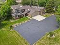 Expansive aerial view of a beautiful home with a large driveway, lush lawn and mature landscaping at 6895 S Norfolk St, Foxfield, CO 80016