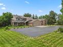 Charming home boasts a grand entrance, three-car garage, and lush landscaping at 6895 S Norfolk St, Foxfield, CO 80016