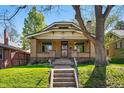 Charming brick home featuring a covered porch, manicured lawn, and easy access via concrete steps at 810 Adams St, Denver, CO 80206