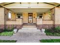Welcoming front porch with decorative brick pillars, concrete steps, and green plants at 810 Adams St, Denver, CO 80206