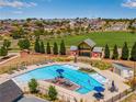 Community pool and barn-styled gazebo surrounded by green spaces, with neighborhood homes at 17035 E 102Nd Pl, Commerce City, CO 80022