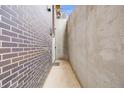 Exterior view of a modern home with a brick wall and concrete wall, showcasing a narrow pathway and minimal design at 718 Emerson Gulch Rd, Boulder, CO 80302