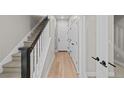Bright hallway with hardwood floors and a staircase with designer dark wood and white railings at 16605 Peak St, Broomfield, CO 80023