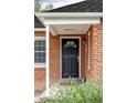 Inviting front door with classic brick surround and covered entry at 2970 Leyden St, Denver, CO 80207