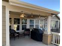 Inviting covered patio features string lights, comfortable seating, and outdoor grill at 15346 Heritage Cir, Thornton, CO 80602