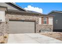 Exterior facade with stone details, two-car garage, concrete driveway and meticulously landscaped front yard at 3522 N Buchanan Way, Aurora, CO 80019