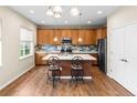 Spacious kitchen with stainless steel appliances, center island with seating, and wood floors at 10771 N Montane Dr, Broomfield, CO 80021