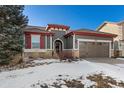 Gray house with red accents and a two-car garage at 14442 E 102Nd Pl, Commerce City, CO 80022