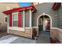 Front entrance with red door and stone accents at 14442 E 102Nd Pl, Commerce City, CO 80022