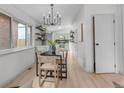 Dining area with a modern chandelier, sleek black table, and an open view to the kitchen at 3619 N York St, Denver, CO 80205